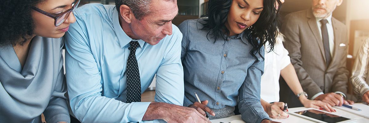 Black and white group of people doing teamwork in contemporary office.